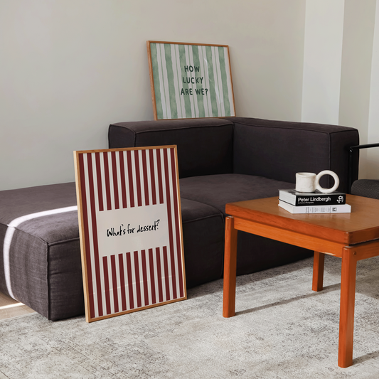 Living room with a brown sofa, wooden coffee table, and decorative frames on the wall.