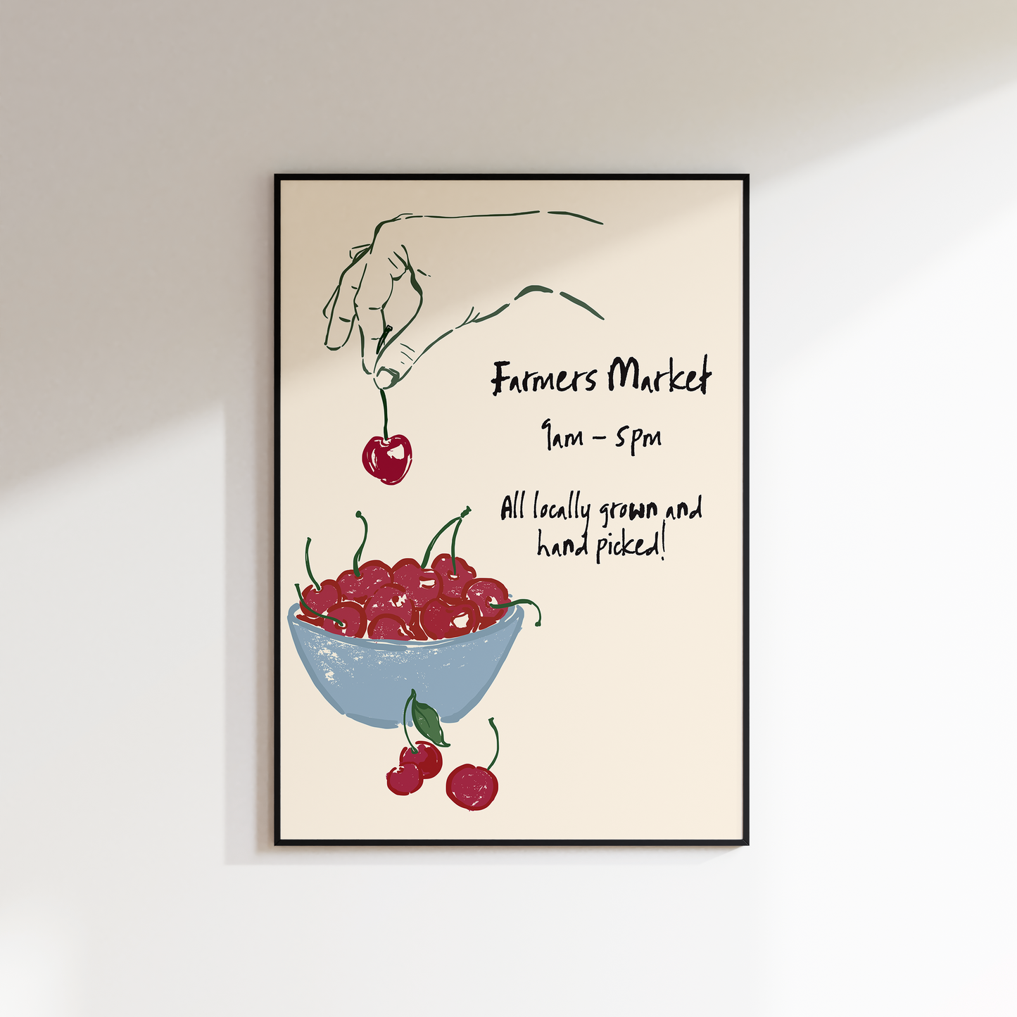 Framed artwork with a hand holding cherries and a bowl of cherries on a beige background.