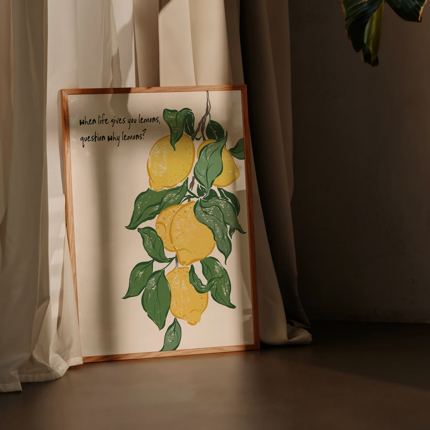 Framed artwork of lemons and leaves against a curtain