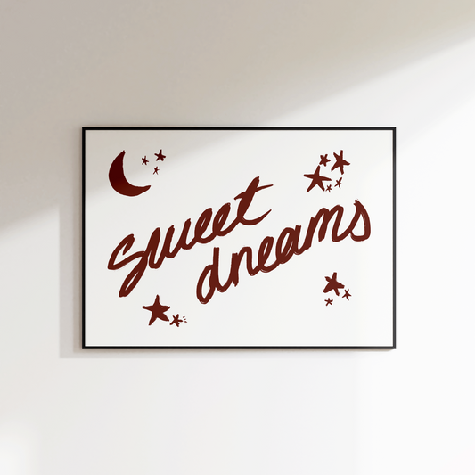 Framed artwork with 'sweet dreams' text and decorative elements on a white wall.