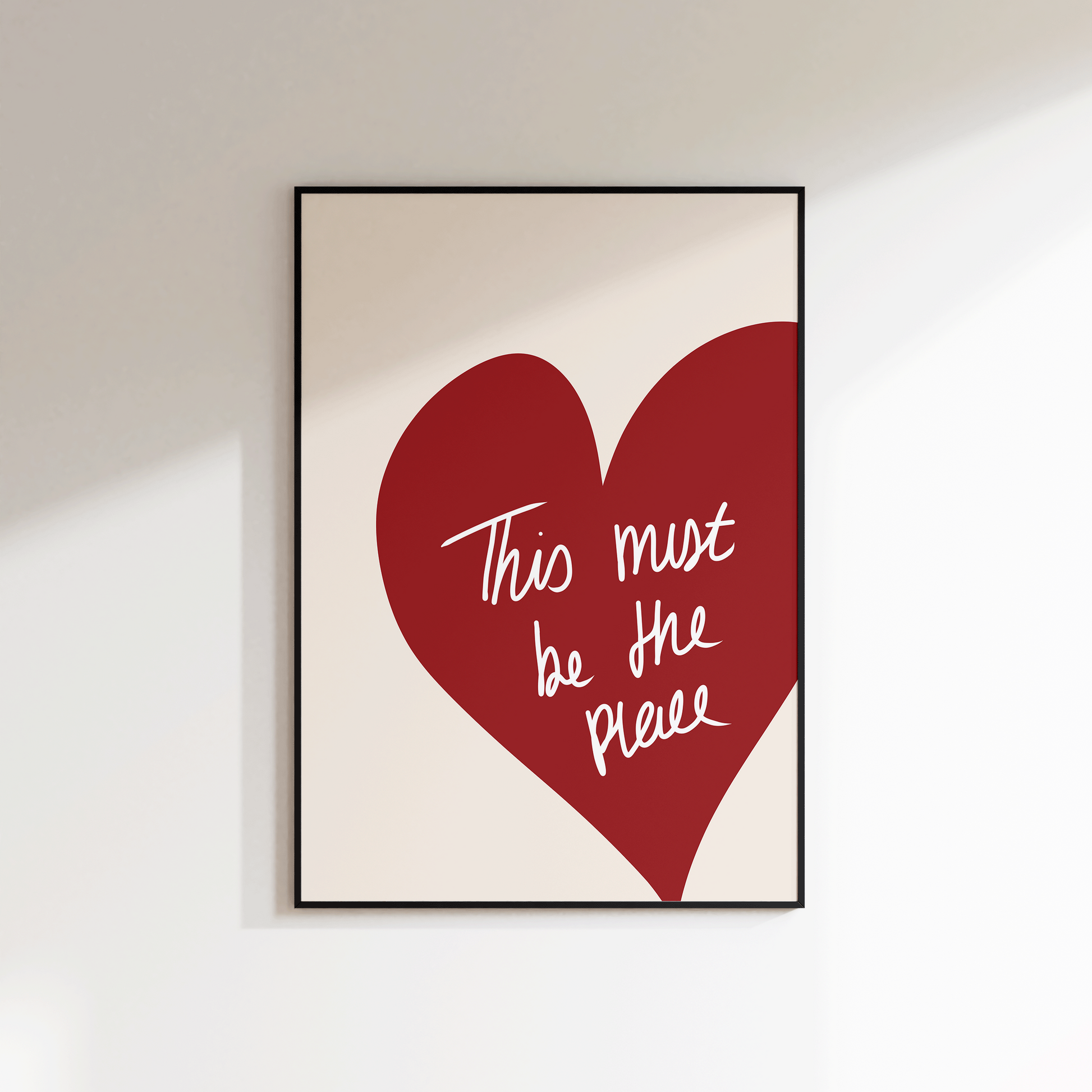 Framed artwork with a red heart and white text on a beige background