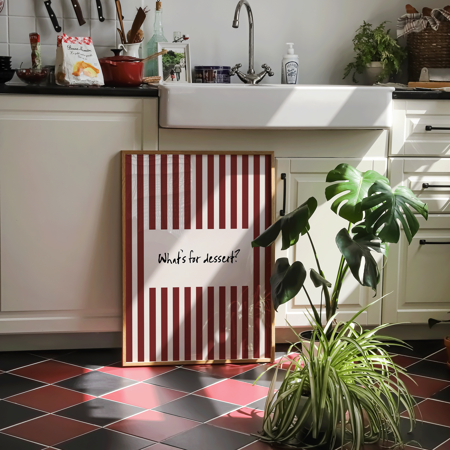 Framed piece of wall art - "what's for dessert? on a striped background - in a kitchen