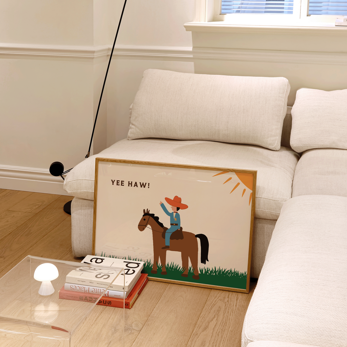 Living room with a white sofa, framed picture of a cowboy on a horse, and a lamp.