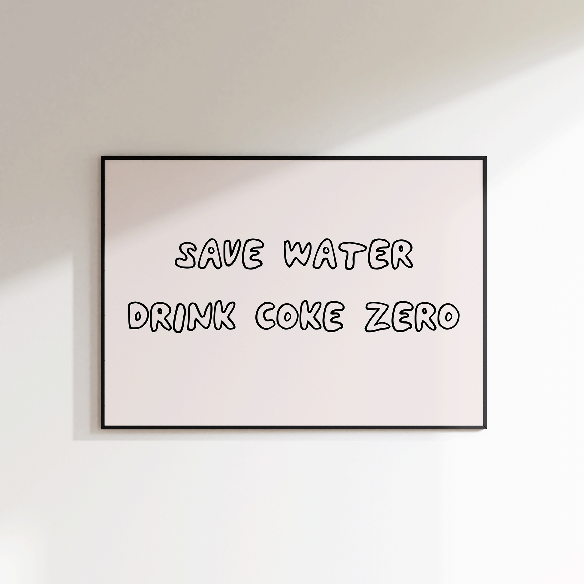 Framed poster with 'Save Water Drink Coke Zero' text on a white wall.