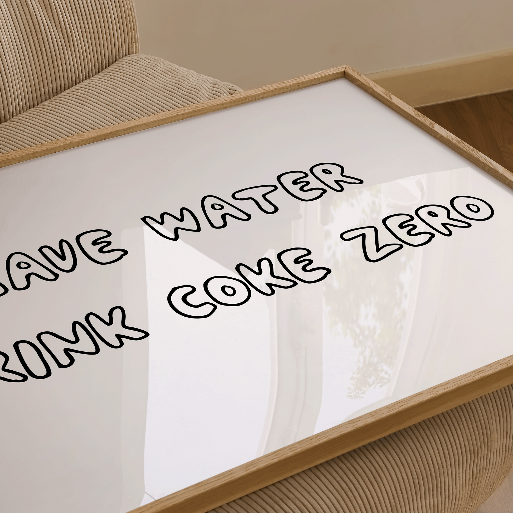 close up of framed art print with the text reading "save water, drink Coke Zero"