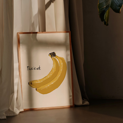 Framed artwork of bananas with 'This is art' text against a curtain background