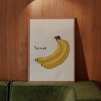 Framed artwork of bananas with text on a wooden wall above a green sofa.