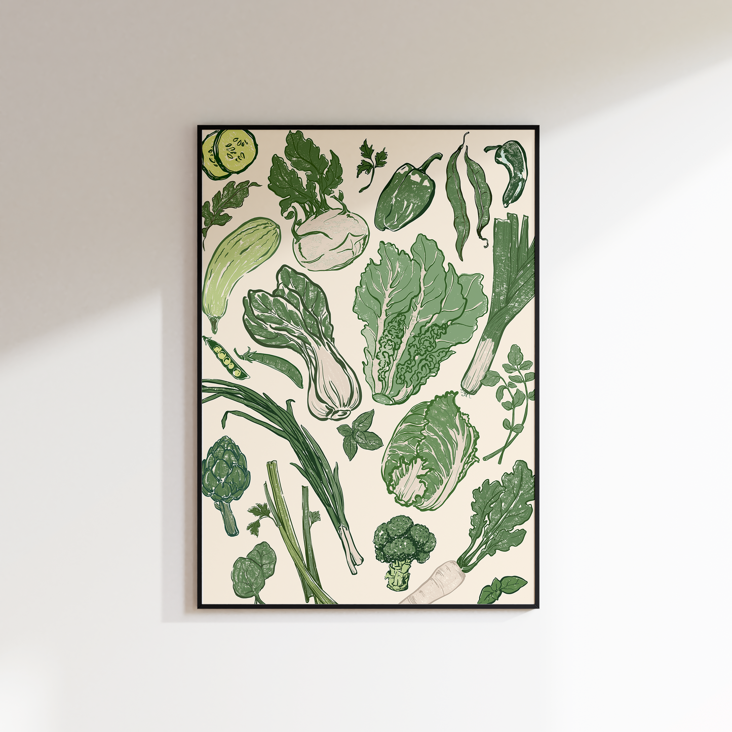 Framed artwork of green vegetables on a white wall