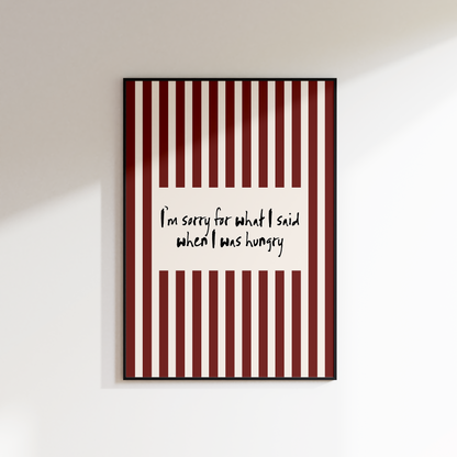 Framed artwork with red and white striped pattern and text on a white wall.