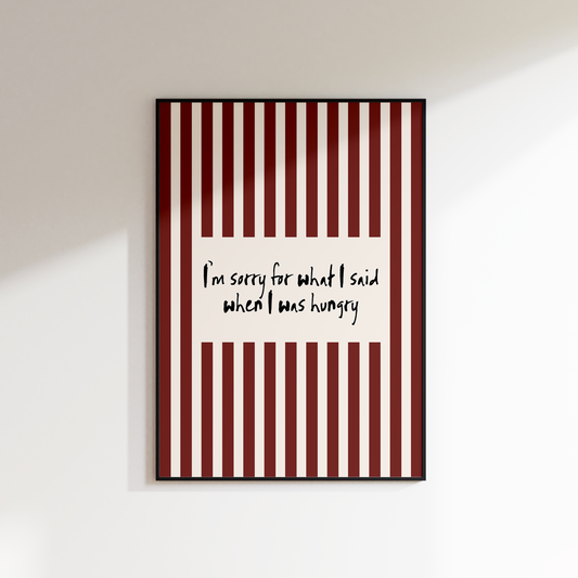 Framed artwork with red and white striped pattern and text on a white wall.