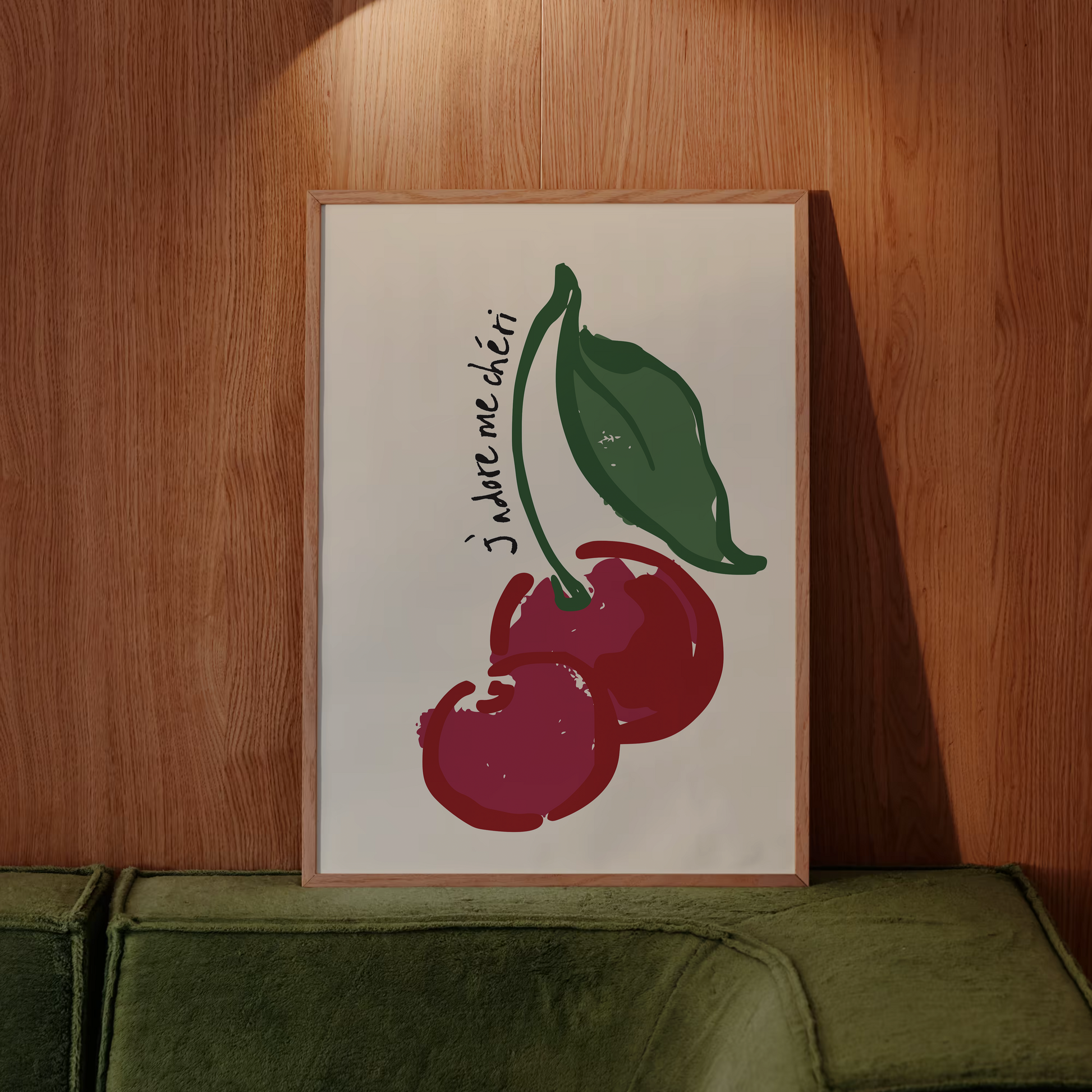 Poster with cherry design and text on a wooden wall above a green sofa