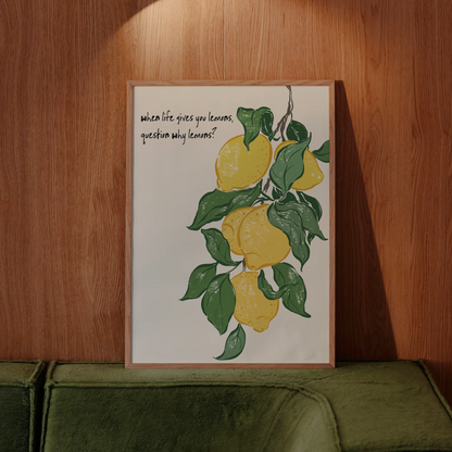 Framed artwork with lemons and text on a wooden wall above a green sofa.